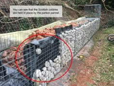 there is a fence that has been built into the side of a building with rocks in it