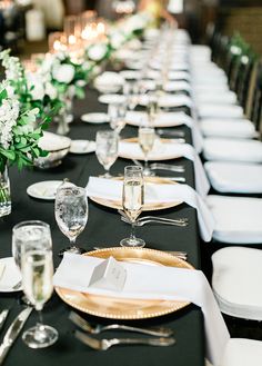 the table is set with white and gold place settings