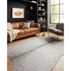 a living room filled with furniture and a rug on top of a hard wood floor