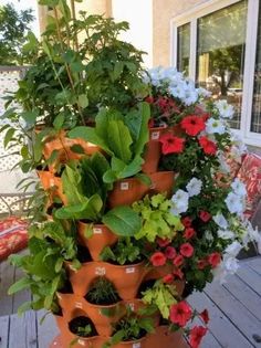 a stack of potted plants sitting on top of a wooden deck