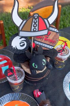 a table topped with paper plates and cups filled with desserts on top of it