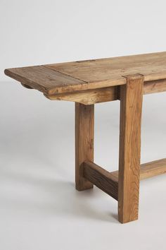 a wooden table with two legs and one leg extended to the side, against a white background