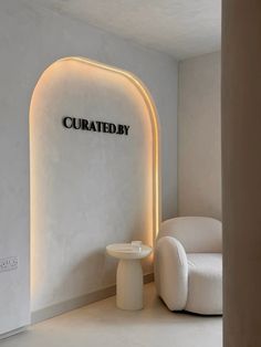 a white chair and table in a room with a circular light fixture on the wall