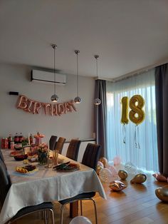 a birthday party is set up in the dining room with balloons and streamers on the wall