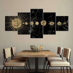 a dining room table with four chairs and a wall hanging art piece on the wall