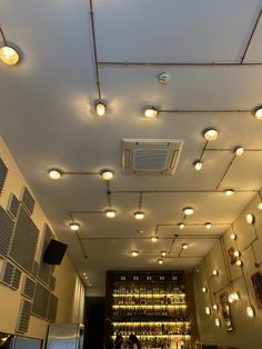 the ceiling is covered with lights and dimmers in an empty room that has several bottles on it