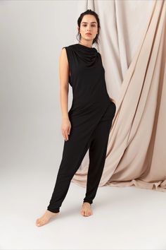 The Black Jumpsuit is the epitome of sleek sophistication and modern style. This one-piece garment seamlessly combines fashion-forward design with versatile functionality. Crafted from a 95% certified lenzing micromodal & 5% spandex fabric. Fancy Cocktail Party, Enby Fashion, African Desert, Black One Piece Jumpsuit, Queer Style, Long Top Dress, Hooded Jumpsuit, Timeless Wardrobe, Conscious Fashion