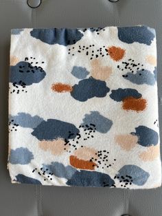 a blanket that is sitting on the back of a chair with buttons attached to it