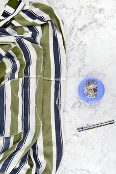 a blue plate with silver flakes on it next to a green and white striped blanket