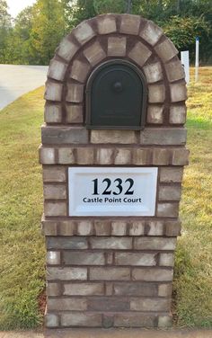 a brick mailbox sitting in the grass