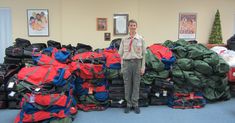 a man standing in front of piles of luggage on the floor next to a pile of bags