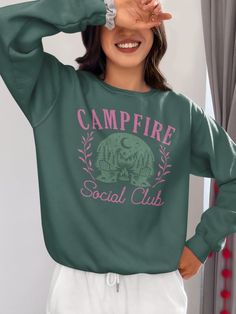 **Camping Social Club Sweatshirt** Embrace the cozy side of adventure with our "Camping Social Club" Sweatshirt, designed especially for women who love the great outdoors. This sweatshirt combines vintage charm with modern comfort, making it the perfect addition to your camping wardrobe. Featuring a distressed look and a nod to forestcore aesthetics, this sweatshirt embodies the spirit of nature and camaraderie. Crafted from soft, high-quality fabric, this sweatshirt offers warmth and comfort, perfect for cool evenings by the campfire or chilly morning hikes. The distressed, vintage-inspired look adds a touch of rustic charm, making this sweatshirt a standout piece. It's also an excellent gift for fellow campers or a special treat for yourself to celebrate your love for camping. ▪️▪️▪️DELI Green Crew Neck Top For Adventure, Green Crew Neck Top For Camping, Casual Fall Tops For Camping, Casual Tops For Fall Camping, Casual Green Top For Camping, Green Tops For Outdoor Activities In Fall, Green Tops For Fall Outdoor Activities, Long Sleeve T-shirt With Letter Print For Camping, Casual Long Sleeve T-shirt For Camping