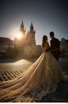 the bride and groom are standing in front of an old castle with sun flares