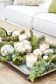 a tray filled with candles and ornaments on top of a table