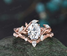 a rose gold engagement ring with an oval cut diamond in the center and leaves on each side