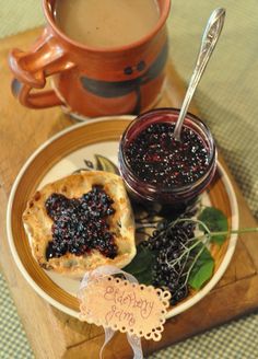 a cup of coffee and some fruit on a plate next to a bowl of berries