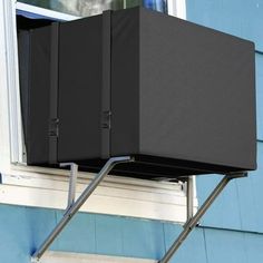 a black box sitting on top of a window sill next to a blue building