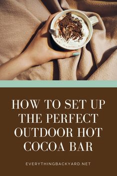 someone holding a cup of hot cocoa in their hand with the words how to set up the perfect outdoor hot cocoa bar