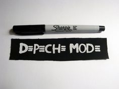 a pen is laying on top of a black and white label that says depech mode