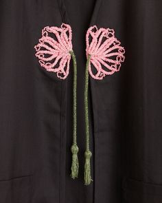 a pink flower is attached to a black jacket