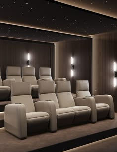 a row of reclining chairs in front of a wall mounted movie projector screen