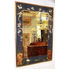 an ornate mirror is hanging on the wall in front of a dresser and lampshade