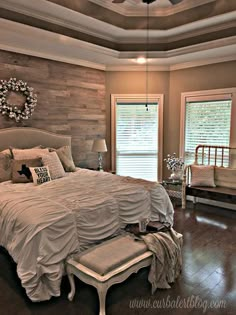 a large bed sitting inside of a bedroom on top of a hard wood floor