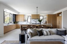 a living room filled with furniture next to a kitchen