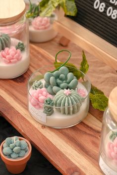 some small pots with plants in them on a wooden table next to other potted plants