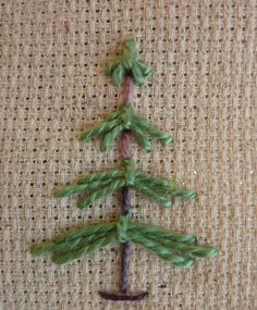 a needled christmas tree on a piece of burlocked fabric with green needles