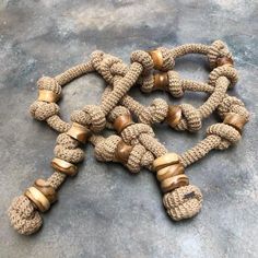 several pieces of rope with wooden beads on them sitting on a table next to each other