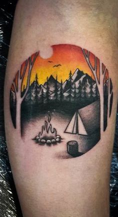 a man's leg with a camping scene tattoo on it