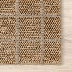 a close up view of a rug on a wooden floor with white and brown colors