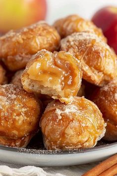 a plate filled with apple pie bites next to cinnamon sticks