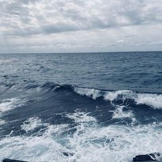 the ocean is very choppy with waves coming in from the water and some clouds