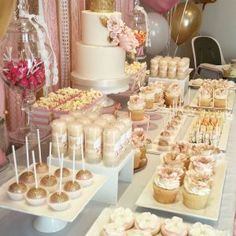 a table topped with lots of cupcakes and cake