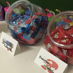 two plastic containers filled with candy sitting on top of a table next to each other