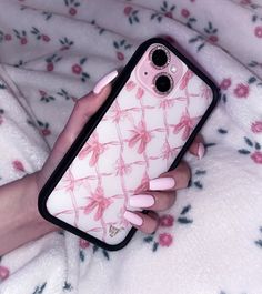 a woman's hand holding an iphone case with pink flowers on it