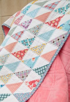 a close up of a quilt on a pink blanket