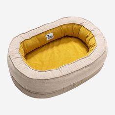 a dog bed with a yellow pillow in the shape of a cat's bed