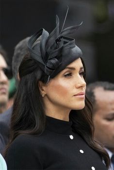 the woman is wearing a black hat and dress