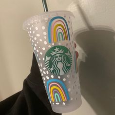 a starbucks cup with a straw sticking out of it's lid and rainbow designs on the side