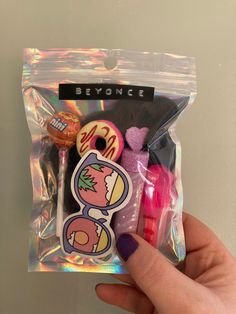 someone is holding up a bag with some stickers on it and there are other items in the package