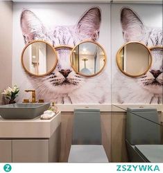 a bathroom with two mirrors and a cat mural on the wall behind the sink area