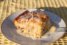 a piece of cake on a plate with a fork in it and drizzled with icing