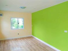 an empty room with green walls and white trim on the windowsill is painted bright yellow