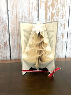 an origami christmas tree is folded in the shape of a book on a table