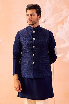 Navy blue nehru jacket featuring asymmetrical floral hand embroidery. Paired with a textured kurta and a white pant. - Aza Fashions Luxury Nehru Jacket With Buttons For Winter, Blue Nehru Jacket For Winter Wedding, Blue Nehru Jacket With Stand Collar For Winter, Blue Winter Nehru Jacket With Stand Collar, Traditional Blue Bandhgala With Stand Collar, Formal Blue Nehru Jacket With Stand Collar, Blue Formal Nehru Jacket With Stand Collar, Blue Nehru Jacket With Stand Collar For Festive Occasions, Blue Nehru Jacket For Semi-formal Winter Events