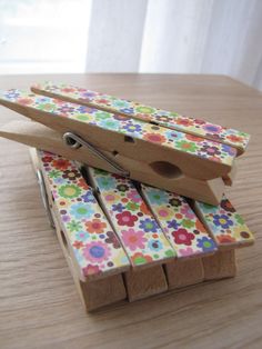 a pair of scissors sitting on top of a wooden block with flower print wrapping around it