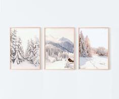 three paintings hanging on the wall with snow covered trees and mountains in the back ground